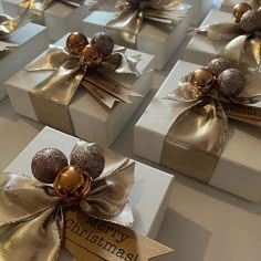 christmas presents wrapped in gold and silver paper with bows, ornaments and tags on them