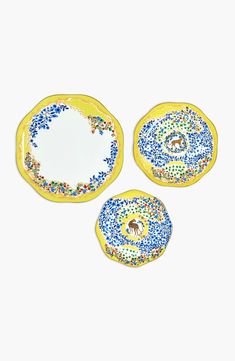 three yellow and blue plates with animals on them, one has an empty plate in the middle