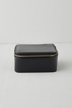 a black leather case with zippers on the inside and outside, sitting on a white surface