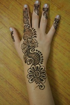 a woman's hand with henna tattoos on it