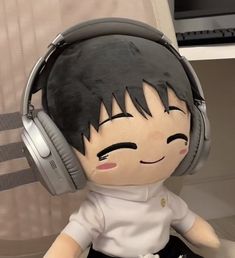 a stuffed doll with headphones sitting on a desk