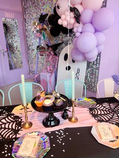 a table topped with lots of balloons and cake