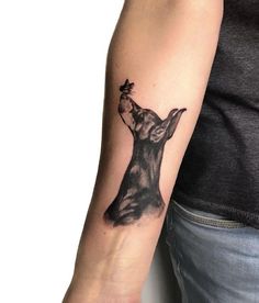 a person with a tattoo on their arm holding a dog's head in the air