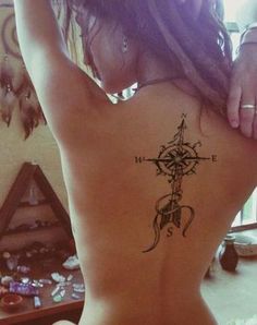 a woman with a compass tattoo on her back