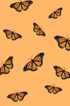 a group of butterflies flying in the air on an orange background with black and white dots