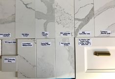 white marble tiles with different types of labels on them and magnets attached to the wall