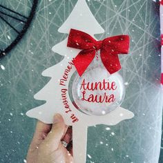 a person holding up a christmas ornament