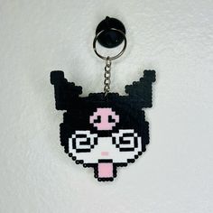 a black and pink keychain with a cartoon character on it