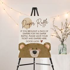 a sign with a bear on it that says, diaper raffle if you brought a pack of diapers for the diaper raffle, please leave your ticket and dapper here good luck