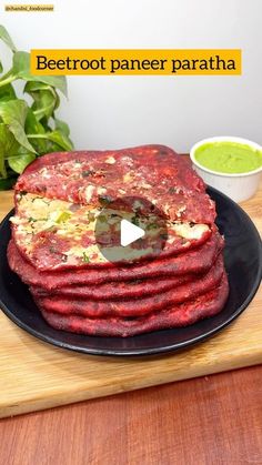 beetroot paneer paratha on a black plate with green chutney