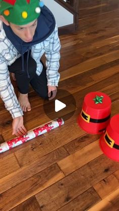 a young boy in a christmas hat playing with some candy canes on the floor