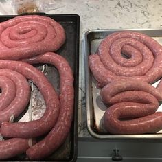 two pans filled with sausage sitting on top of a counter