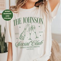 a woman wearing a t - shirt that says the johnson social club with two champagne glasses on it