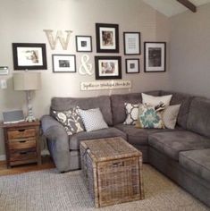 a living room with gray couches and pictures on the wall above it's coffee table