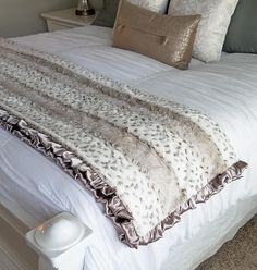 a white bed with pillows and blankets on it