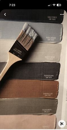 a paint brush sitting on top of some different shades of paint in the same color