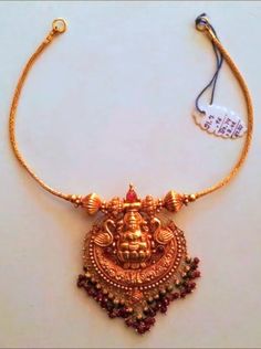 a gold necklace with an elephant head on it