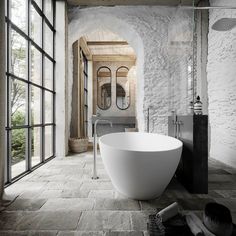 a large white bath tub sitting next to a window