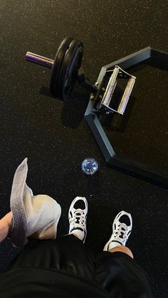 a person with their feet on the ground next to a barbell