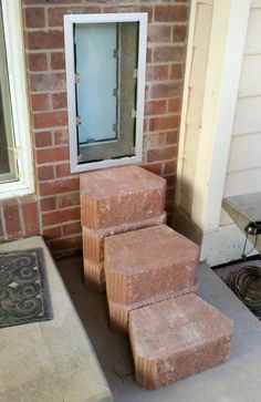 three bricks stacked on top of each other in front of a house with a window