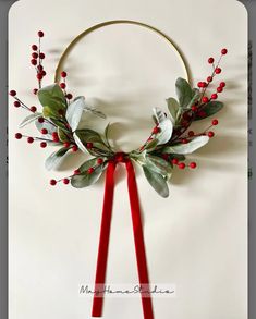 a wreath with red berries and greenery on it