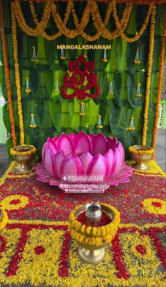 a decorated stage with flowers, candles and garlands on the ground in front of it