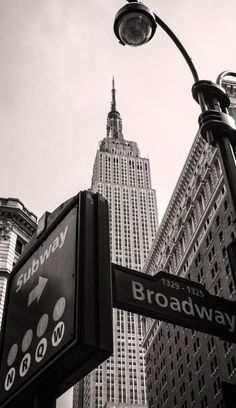 street signs in front of the empire building and broadway sign on 42nd avenue, new york city