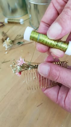 a person holding a hair comb in their left hand and some flowers on the other