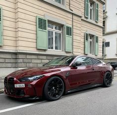 a red sports car is parked on the side of the road in front of a building