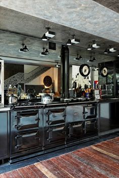 a large kitchen with black cabinets and an area rug on the floor that matches the ceiling