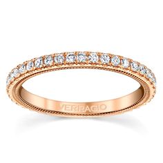 a rose gold wedding band with rows of diamonds on the sides and an inscription that reads,