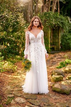 a woman in a wedding dress standing on a path