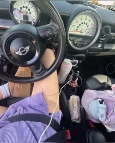 the interior of a car with steering wheel and various items on the floor, including an infant's diaper