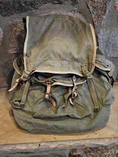 Vintage BOY SCOUT #190 Rucksack Canvas Bag, 1950's, Front Flap has insignia with #190 Rucksack WSF little fading due to age, features drawstring for inside closure and dual buckle flap for main outside closure, one leather strap on front pocket is not attached to canvas (See picture for details). 2 side pockets with buckle closure, some staining and spots on canvas (See picture for details) has backpack straps and metal frame for support. In decent condition. Old Backpack Aesthetic, Vintage Adventure Backpack With Pockets, Vintage Standard Backpack For Adventure, Vintage Travel Backpack With Pockets, Vintage Backpack With Pockets, Vintage Backpack For Everyday Use, Vintage Outdoor Backpack With Pockets, Vintage Canvas Backpack For Outdoor Activities, Vintage Backpack For Outdoor Activities