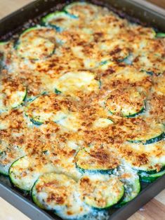 zucchini and cheese casserole in a baking dish on a wooden table