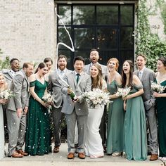 a group of people standing next to each other in front of a building with confetti