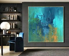 a large abstract painting on the wall in a living room with blue chairs and bookshelves