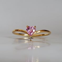 This 14K Pink Sapphire Heart ring makes for a perfect promise ring, or as a gift for your beloved. Nothing like saying "I love you" with this dainty beauty top with a natural white diamond. Perfect to wear alone or stacked with other ring bands. Available in 14k yellow gold, rose gold, and white gold. Pair it with our Siren Marquise ring or Winter Palace Marquise ring (as pictured) for the ultimate majestic look. This ring is designed and made in NYC. 14k solid gold band Natural pink heart sapph