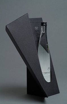 an empty bottle in a black box on a grey background with the lid open to show it's contents