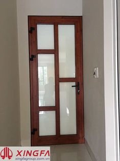 an empty room with a wooden door and glass panels on the outside wall, in front of a window