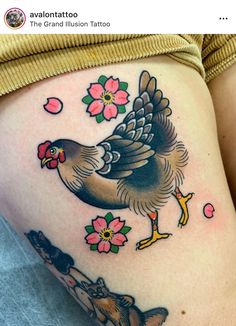 a woman's thigh with a rooster and flowers on her side, tattoo style