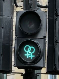 a traffic light with an image of the female symbol painted on it's green