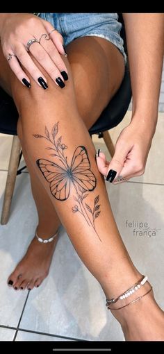 a woman's leg with a butterfly tattoo on it