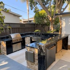 an outdoor kitchen with grills and sink