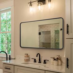 a bathroom with a large mirror above the sink and two faucets in front of it