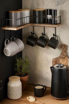 coffee pots and cups are hanging on the wall