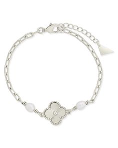 Elevate your style with the Tilda Pearl & Clover Charm Bracelet. The lustrous pearls and delicate clover charm create a sophisticated look, while the link bracelet adds a touch of elegance. Perfect for any occasion, this bracelet will be a timeless addition to your collection. Materials: 14K gold or rhodium plated brass Features: Measures 7" with 1" extender, 15x15mm clover, 2-5x7mm pearls, 3x6 oval links, Lead and Nickel free, Lobster clasp Elegant Metal Bracelets With Flower Charm, Silver Dainty Pearl Bracelet, Dainty Silver Metal Pearl Bracelet, Elegant Silver Bracelet With Flower Charm, Silver Metal Charm Bracelet With Pearl Charm, Solid Gold Bracelet, Clover Charm, Statement Drop Earrings, Mens Accessories Jewelry