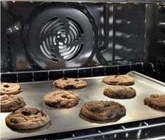 chocolate chip cookies baking in an oven on a pan with the door open to allow more than one cookie