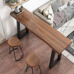 a wooden table sitting next to two stools on top of a hard wood floor