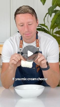 a man in an apron is making ice cream with his hands and holding a bowl